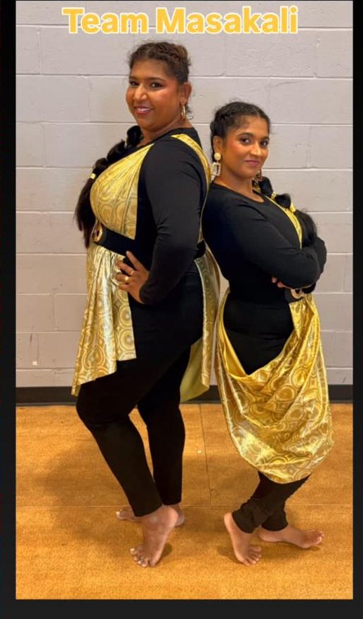 Two Masakali dancers in black and gold costumes