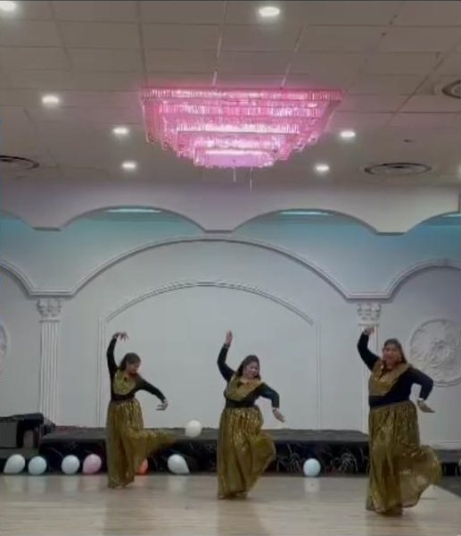 Three Masakali dancers in gold performing in a banquet hall